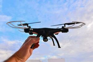 a person holding a remote control drone in the air photo