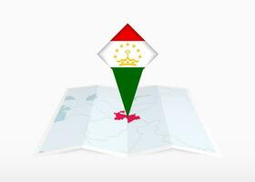 Tajikistan is depicted on a folded paper map and pinned location marker with flag of Tajikistan. vector