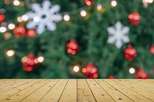 Empty wood table top with blur Christmas tree with bokeh light background photo