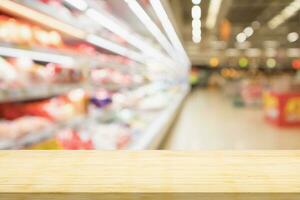 Empty wood table top with supermarket blurred background for product display photo