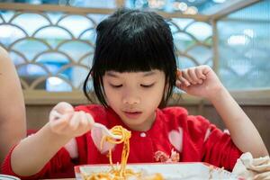 linda pequeño asiático niño niña comiendo comida foto