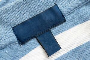 blanco azul lavandería cuidado ropa etiqueta en camisa tela textura antecedentes foto
