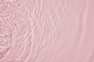 Abstract transparent water shadow surface texture natural ripple on pink background photo