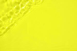 Abstract transparent water shadow surface texture natural ripple on yellow background photo