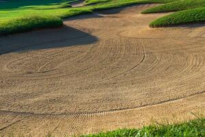 Golf Course Sand Pit Bunkers, green grass surrounding the beautiful sand holes is one of the most challenging obstacles for golfers and adds to the beauty of the golf course. photo