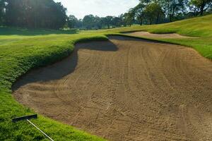 Golf Course Sand Pit Bunkers, green grass surrounding the beautiful sand holes is one of the most challenging obstacles for golfers and adds to the beauty of the golf course. photo