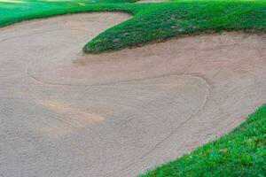 Golf Course Sand Pit Bunkers, green grass surrounding the beautiful sand holes is one of the most challenging obstacles for golfers and adds to the beauty of the golf course. photo