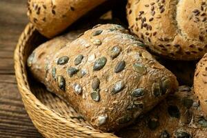 Cesta de mimbre con selección de panes y bollería. surtido de productos horneados foto