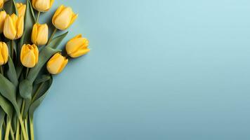 AI generated Bright yellow tulips on blue background with copy space for text. Fresh spring flowers bouquet. Flat lay, top view. Minimal floral banner. Easter, Valentines day, Mothers day concept photo