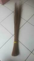 Sapu lidi is a cleaning tool for yards, gardens, or roadsides. It is widely used in residential areas, offices, or by sanitation workers. Made from the fronds of trees. photo