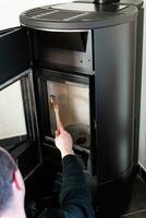 Man cleaning pellet stove with brush photo