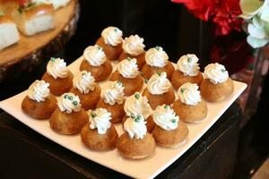 Sweet cakes with whipped cream on a white plate. Selective focus. photo