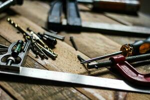 un conjunto de carpintería herramientas en contrastando tonos en el madera piso. foto