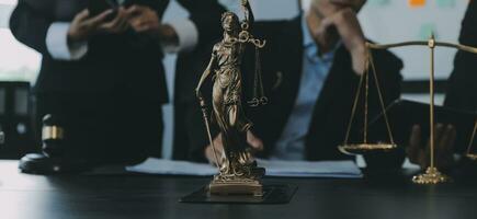 Business and lawyers discussing contract papers with brass scale on desk in office. Law, legal services, advice, justice and law concept picture with film grain effect photo