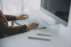 el retrato de una joven mujer asiática independiente está trabajando en su trabajo en una tableta de computadora en una oficina moderna. hacer un informe de análisis contable datos de inversión inmobiliaria, concepto de sistemas financieros y fiscales. foto