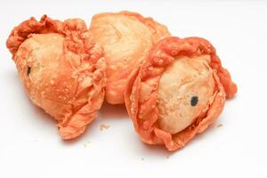 Fried flour snack or curry puff filled with chicken, a popular snack in Thailand. placed on a white background photo