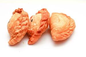 Fried flour snack or curry puff filled with chicken, a popular snack in Thailand. placed on a white background photo