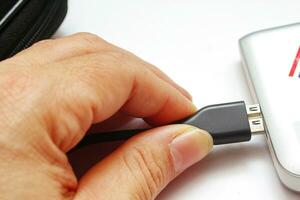 Close up of a man's hand holding a USB flash drive or USB cable 2 photo