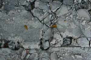 Broken concrete floor with crack in the ground. Close up. photo