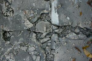 Broken concrete wall texture. Cracks and cracks in the road. photo