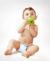 Baby boy eating apple photo