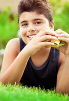 contento chico comiendo hamburguesa foto
