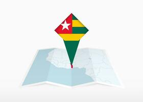 Togo is depicted on a folded paper map and pinned location marker with flag of Togo. vector