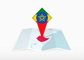 Etiopía es representado en un doblada papel mapa y clavado ubicación marcador con bandera de Etiopía. vector