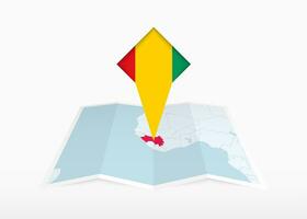 Guinea is depicted on a folded paper map and pinned location marker with flag of Guinea. vector