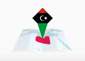 Libya is depicted on a folded paper map and pinned location marker with flag of Libya. vector