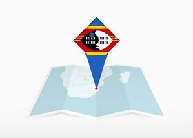 Swazilandia es representado en un doblada papel mapa y clavado ubicación marcador con bandera de swazilandia vector