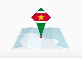 Surinam es representado en un doblada papel mapa y clavado ubicación marcador con bandera de surinam vector