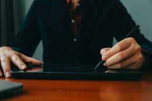 Asian Businesswoman Using laptop computer and working at office with calculator document on desk, doing planning analyzing the financial report, business plan investment, finance analysis concept. photo
