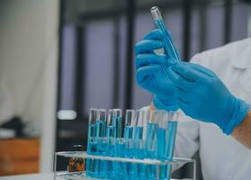 Scientist or medical in lab coat working in biotechnological laboratory, Microscope equipment for research with mixing reagents in glass flask in clinical laboratory. photo