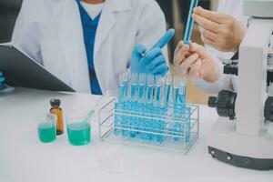 Scientist or medical in lab coat working in biotechnological laboratory, Microscope equipment for research with mixing reagents in glass flask in clinical laboratory. photo