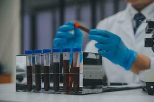Scientist or medical in lab coat working in biotechnological laboratory, Microscope equipment for research with mixing reagents in glass flask in clinical laboratory. photo