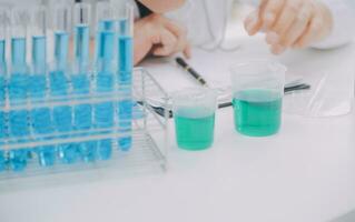 Scientist or medical in lab coat working in biotechnological laboratory, Microscope equipment for research with mixing reagents in glass flask in clinical laboratory. photo