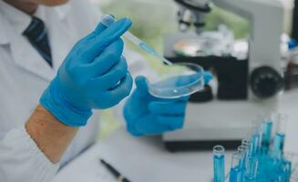 Scientist or medical in lab coat working in biotechnological laboratory, Microscope equipment for research with mixing reagents in glass flask in clinical laboratory. photo