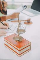 Business and lawyers discussing contract papers with brass scale on desk in office. Law, legal services, advice, justice and law concept picture with film grain effect photo