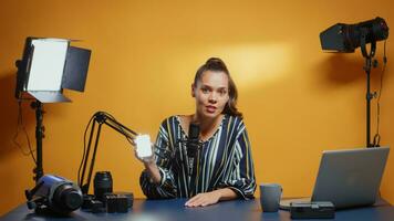 Video blogger doing a mini LED light review in her professional studio set. photo