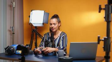 Content creator reviewing fluid head to the camera in her professional studio. Social media influencer making online internet content about video equipment for web subscribers and distribution, digital vlog talking film photo