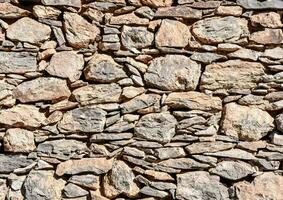 a wall made of stone with many different shapes photo