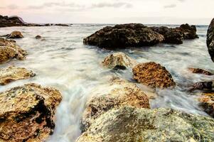 un rocoso playa con olas y rocas foto