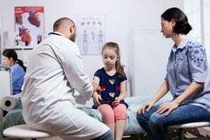 Child general medical check up in hospital office. Healthcare physician specialist in medicine providing health care services treatment examination. photo