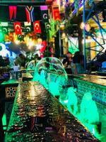 a bar with green lights and a fountain photo