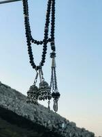 a necklace with black beads hanging from a rope photo