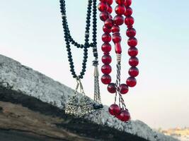a necklace with beads hanging from a rope photo