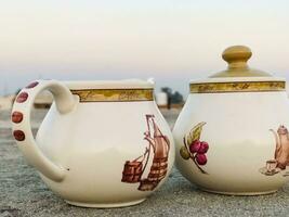 two white and brown jugs with designs on them photo