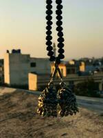a necklace with two black beads hanging from a rope photo