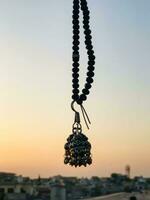 a necklace with red beads hanging from a wall photo